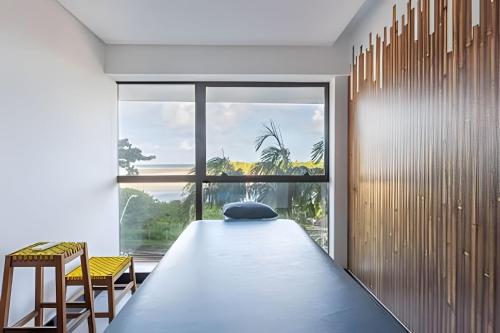 a room with a bed and a large window at BHS Flat a beira mar 2203 in Recife