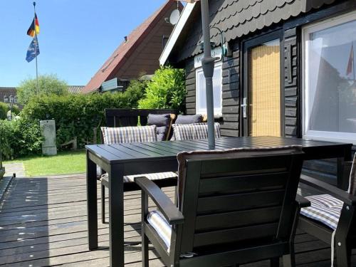 a wooden table and chairs on a deck at Ferienhaus Muckelbude in Bedekaspel
