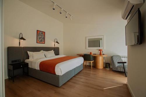 a bedroom with a bed and a desk and a table at Artifact Apart Hotel in Tbilisi City