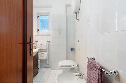 a white bathroom with a toilet and a sink at Ulivello House Sea View in Massa Lubrense