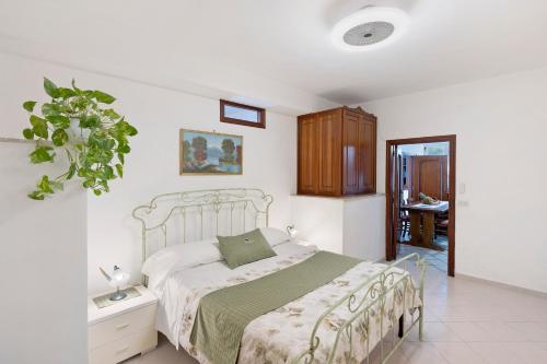 a bedroom with a bed with a green bedspread at Ulivello House Sea View in Massa Lubrense