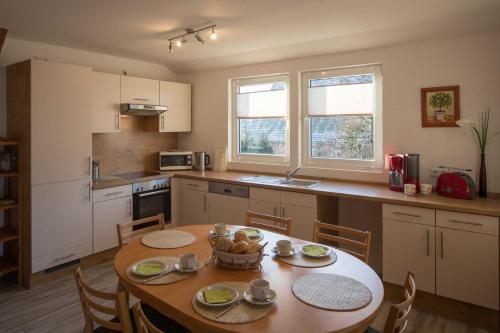 a kitchen with a wooden table with chairs and a dining room at FEWO Maisonettenwohnung in Steinkirchen