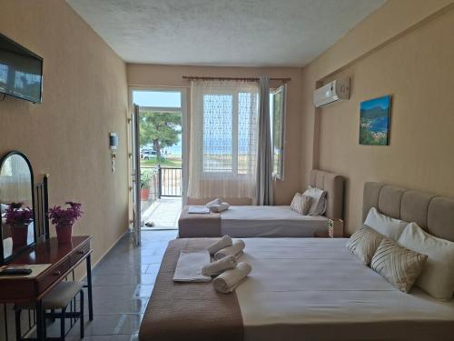 a hotel room with two beds and a desk at Studio Lazaridi in Skala Rachoniou