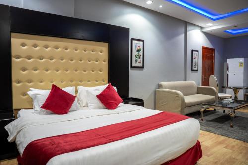 a bedroom with a large bed with red pillows at راحتي هنا in Riyadh