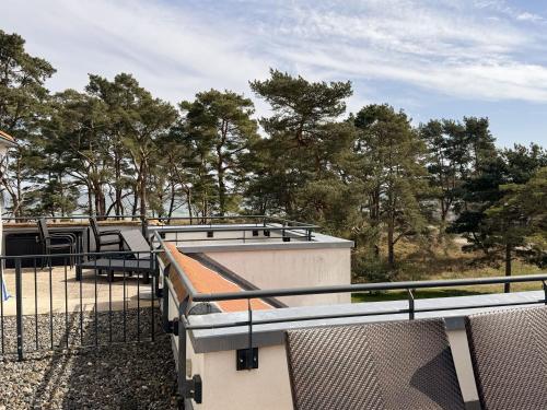 a building with a fence and trees in the background at Haus Meeresblick A 2 12 BLU in Baabe