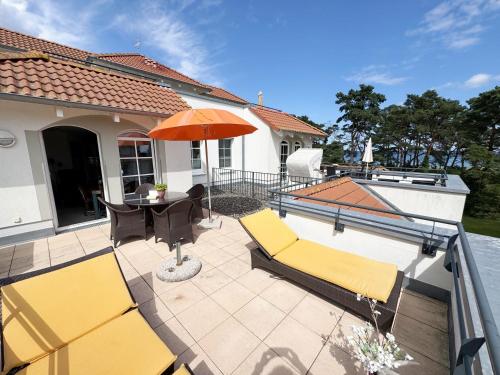 a patio with two chairs and an umbrella at Haus Meeresblick A 2 12 BLU in Baabe