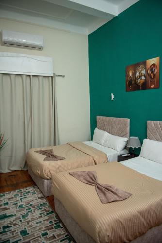 a room with two beds and a green wall at Cairo Center in Cairo
