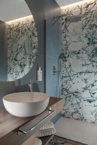 a bathroom with a sink and a shower with a mirror at Parioli Hotel Rimini in Rimini