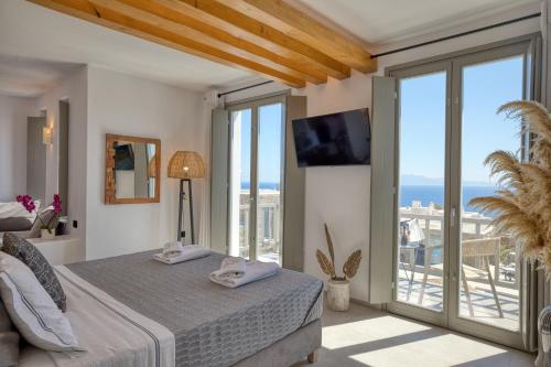 a bedroom with a bed and a view of the ocean at Ionic Suites in Super Paradise Beach