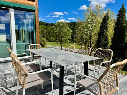 a table and chairs on a patio with a view at Gipfelruhe-ganzes Ferienhaus mit Sauna, Garten & Spielzimmer- Ramsau am Dachstein in Ramsau am Dachstein