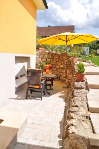 a patio with a table and an umbrella at FEWO Geisbergblick in Zeegendorf