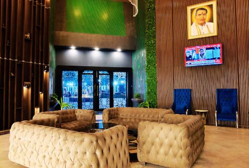 a lobby with chairs and a table and a tv at Shakti Resort in Behror