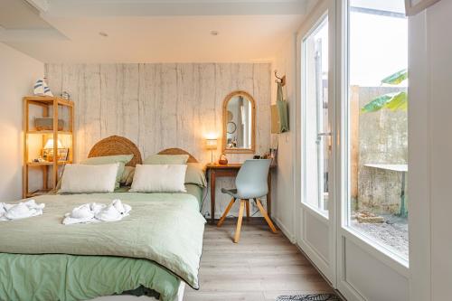 a bedroom with two beds and a desk and a window at Chambre d'hôtes La Beunaise in Rochefort