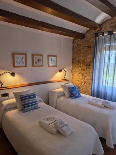 two beds in a room with a window at Mas Palou in Pla del Panadés