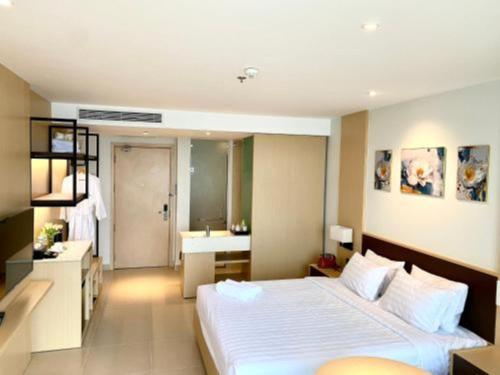 a bedroom with a large bed and a bathroom at Arena jakovi condotel in Cam Lâm