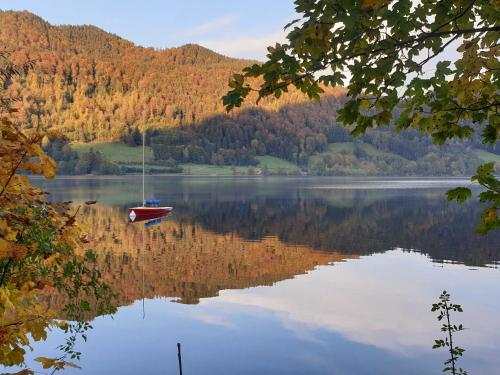 a boat is sitting on a lake with trees at Landhaus SeenSucht in Schliersee