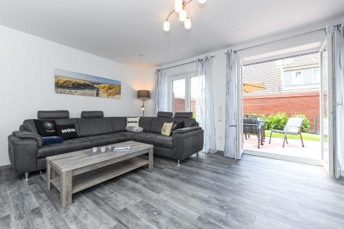 a living room with a couch and a table at Ferienhaus Ella in Dornumersiel