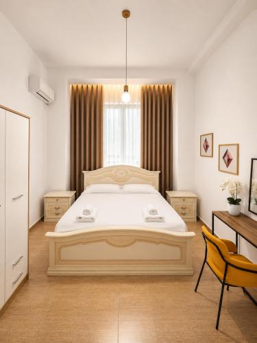 a bedroom with a large white bed and a desk at Friends Home in Tirana
