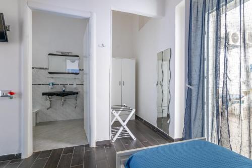 a bedroom with a bed and a bathroom with a sink at Le Camere Di Anna in Gallipoli