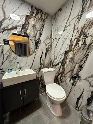 a bathroom with a white toilet and a sink at tuzla first house in Tuzla