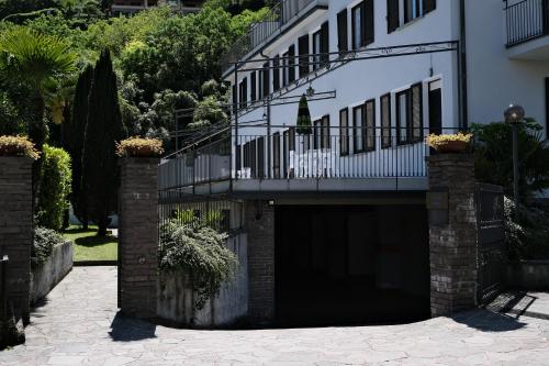 a large building with a garage with a balcony at Hotel Sonenga in Menaggio
