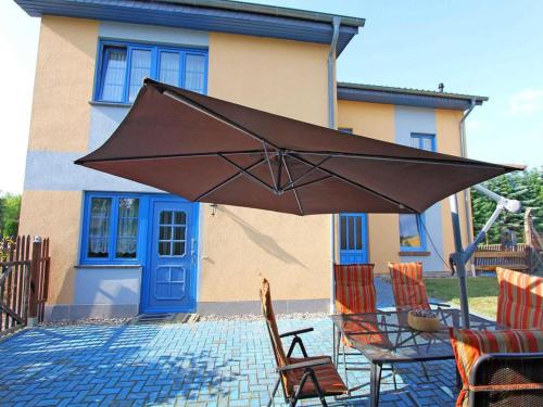 a large brown umbrella in front of a house at Grischow Ferienwohnung in Grischow