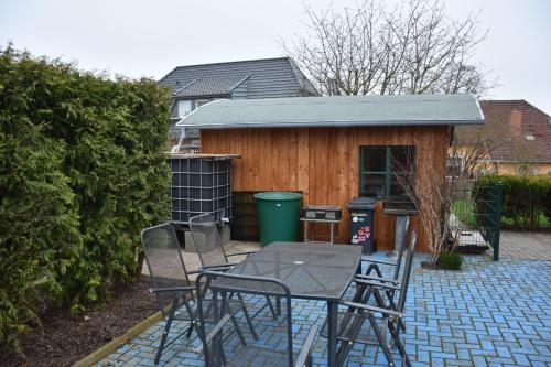 a patio with a table and chairs and a shed at Grischow Ferienwohnung in Grischow