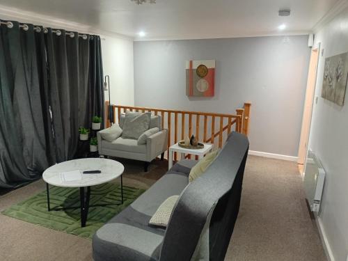 a living room with a couch and a table at Shetcliffe Lodge in Dudley Hill