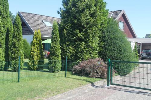 a fence in front of a house with trees at Thiessen - Ferienwohnung mit sonnigem Balkon in Silberstedt