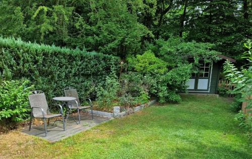 a patio with chairs and a table in a garden at Ferienhaus Paulsen - gemütliches Häuschen mit vollständig eingezäuntem Garten und Kamin in Silberstedt