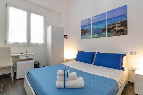 a bedroom with a blue and white bed and a desk at Le Camere Di Anna in Gallipoli