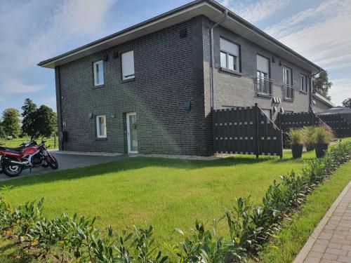 a house with a motorcycle parked in front of it at Ferien am Idasee 85041 in Ostrhauderfehn