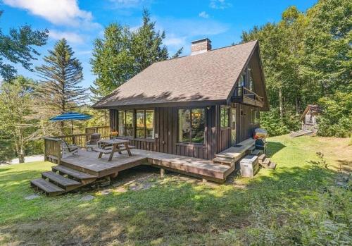 a small cabin with a picnic table and an umbrella at Smugglers Trove in Cambridge