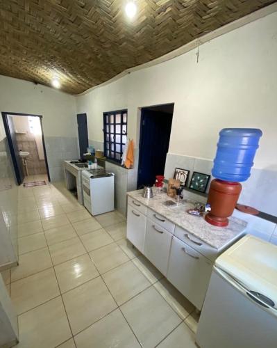 a large kitchen with a large blue bucket on the counter at Quinta da Ana, Casa de Roça in Baependi