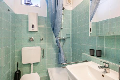 a bathroom with a toilet and a sink and a mirror at Apartment Korthals 42 in Wangerland