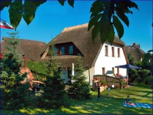 a large white house with a thatched roof at Ruegen_Fewo 233 in Groß Zicker