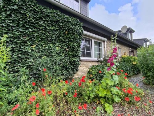 a garden in front of a house with flowers at Ferienwohnung Hinz - Gemütliche Unterkunft für 2 Personen mit modernem Bad in Ellingstedt
