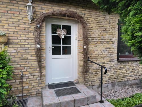 a white door on a brick house with an archway at Ferienwohnung Hinz - Gemütliche Unterkunft für 2 Personen mit modernem Bad in Ellingstedt
