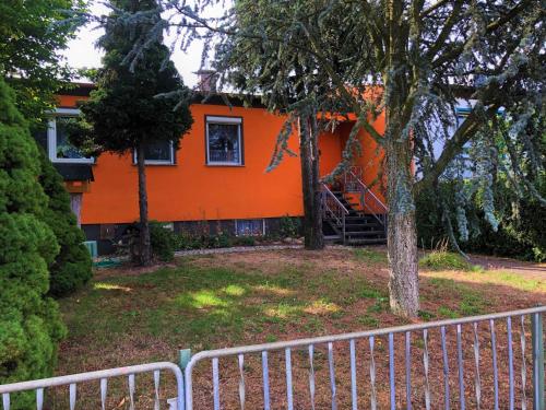 an orange house with a playground in the yard at Ferienhaus am Wiesenweg in Hosena