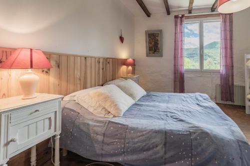 a bedroom with a bed and a table with a lamp at La Barraço in Nalzen