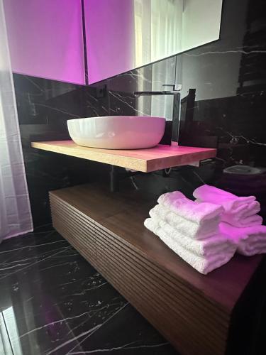 a bathroom with a sink and towels on a shelf at Romantic Spa del Lago in Viverone
