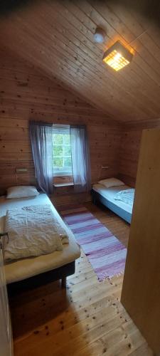 a bedroom with two beds in a wooden cabin at timber cabin Eresfjord med båt til leie in Øverås