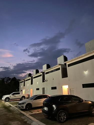 two cars parked in a parking lot in front of a building at Las Orquídeas in Tepoztlán