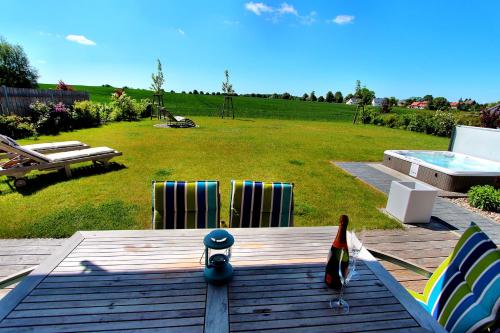 a deck with chairs and a pool in a yard at Villa Anima in Göhren-Lebbin