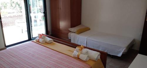 two beds sitting in a room with a window at B&B Josefine in Marina di Camerota