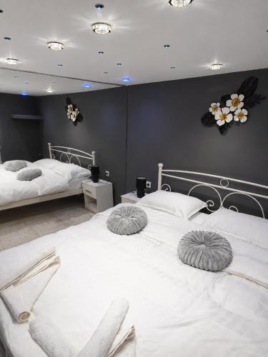 a bedroom with two beds with white sheets at Giorgos Suite - Jacuzzi Hideaway in Lydia, Kavala in Lidia