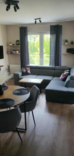 a living room with a couch and two tables at Mazury Home Apartament in Giżycko