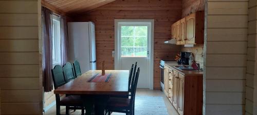 a kitchen with a wooden table and a refrigerator at timber cabin Eresfjord med båt til leie in Øverås