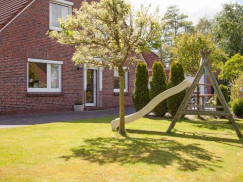 a slide in a yard in front of a house at Birgits Huuske in Stedesdorf