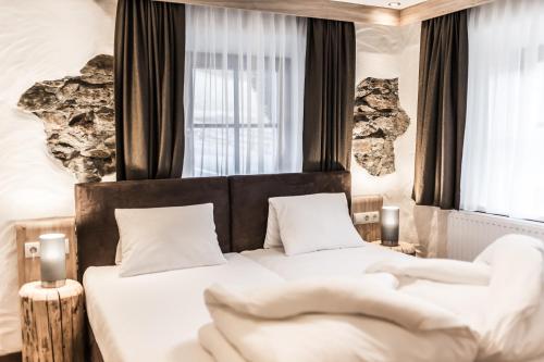 a bedroom with two beds and two windows at A Casa Smaragd Appartements in Sölden
